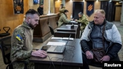 A volunteer hoping to join Ukraine's 3rd Separate Assault Brigade talks to a recruitment officer. (file photo)