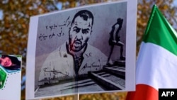 Protestatarii țin pancarte cu portretul rapperului iranian Toomaj Salehi, aflat în detenție la momentul respectiv, și portrete ale copiilor (stânga) care au fost uciși în timpul protestelor din Iran. (fotografie de arhivă)