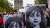 O femeie ține un banner cu portretul unui copil migrant dispărut în timpul unui protest organizat în solidaritate cu migranții care au fost trimiși înapoi în Belarus. Fotografie realizată la data de 17 octombrie 2021.