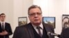 Расейскі пасол у Турэччыне Андрэй Карлаў. Празь некалькі хвілін чалавек, які стаіць у яго за сьпінай, пачне ў яго страляць.