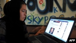 Egy afgán nő görgeti a Facebookot egy kabuli internetkávézóban, még a tálibok 2021-es hatalomátvétele előtt.