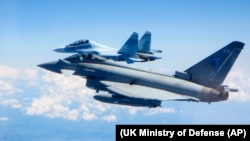 Истребитель Typhoon Королевских ВВС (на переднем плане) пролетает мимо истребителя Су-30 (иллюстративное фото)