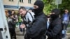 Полиция наразылық шеруіне шыққан адамды ұстап, көлікке салып жатыр. Алматы, 1 мамыр 2019 жыл.