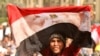 Egypt -- An anti-government protester waves a bloodstained Egyptian flag in Cairo's landmark Tahrir Square, 04Feb2011