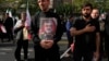 عکس امیرعلی حاجی‌زاده، فرمانده پیشین هوافضای سپاه پاسداران، در دست یکی از هواداران جمهوری اسلامی پس از کشته شدن او در بمباران نیروی هوایی اسرائیل