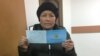 Kazakhstan - Sairagul Sauytbai shows her new document which gives her right to stay in Kazakhstan for another 3 months. Almaty, 28January2019