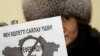 Алматыдағы ЕҚЫҰ кеңсесі алдында плакат ұстап тұрған белсенді. Қаңтар айы, 2011 жыл.