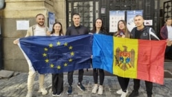 Грамадзяне Малдовы ў Румыніі трымаюць эўрапейскія і малдоўскія сьцягі на выбарчым участку дыяспары ў Бухарэсьце. Ілюстрацыйнае фота