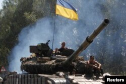 Militari ucraineni în apropiere de orașul separatist Luhansk. Orașul e lipsit de electricitate și gaz de mai multe zile.