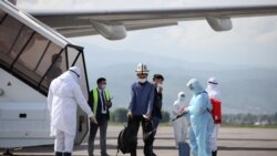Қорғаныс киімін киген жұмысшы Жапония мен Оңтүстік Кореядан келген қырғыз азаматтарының киімдерін залалсыздандырып жатыр.