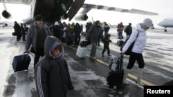 Russia -- Russian citizens, who were evacuated from Libya, leave a plane owned by the Emergency Situations Ministry as they walk along a landing runway at Domodedovo airport outside Moscow, 23feb2011