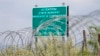 Georgia -- A warning sign is pictured behind a wire barricade erected by Russian and South Ossetian troops along Georgia's de-facto border with its breakaway region of South Ossetia in the village of Khurvaleti, July 14, 2015