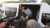 Kazakhstan - Men react inside a police minibus after they were detained during a protest rally held by Kazakh opposition supporters in Almaty, Kazakhstan July 6, 2019. REUTERS/Pavel Mikheyev